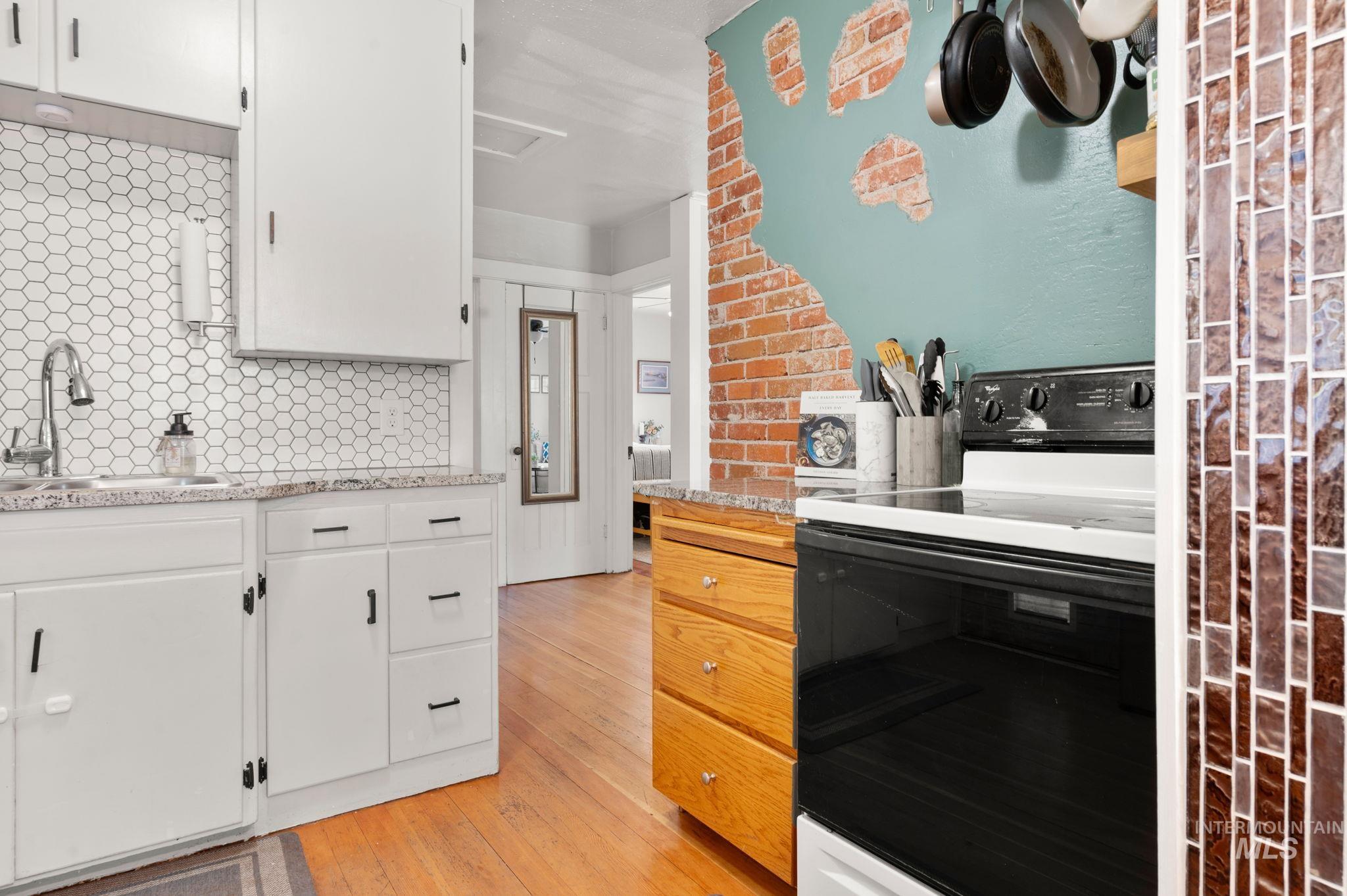 907 3rd Street Lewiston, ID 83501 - Photo 10 of 26 Kitchen featuring range with electric stovetop, white cabinets, and light stone counters