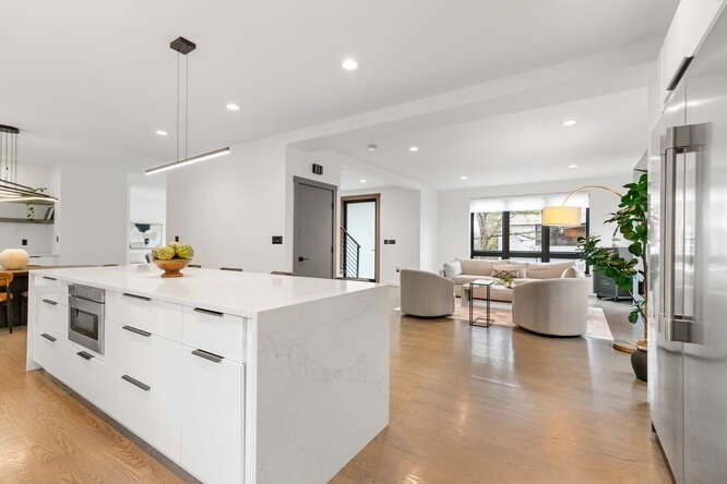 46 Beverly Road Arlington, MA 02474 - Photo 11 of 42 a large white kitchen with kitchen island a stove a couch a dining table and chairs