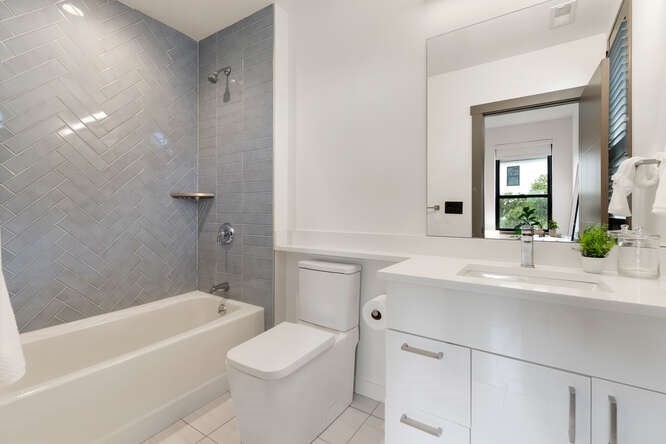 46 Beverly Road Arlington, MA 02474 - Photo 26 of 42 a bathroom with a sink a toilet a mirror a vanity and bathtub