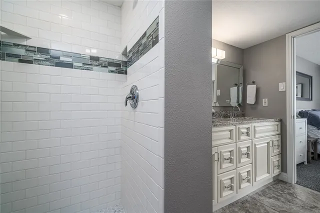 a bathroom with a granite countertop toilet sink and mirror