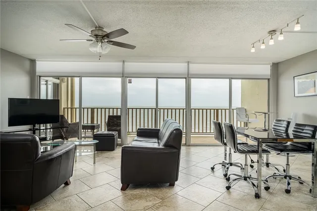 a living room with furniture tv and a floor to ceiling window