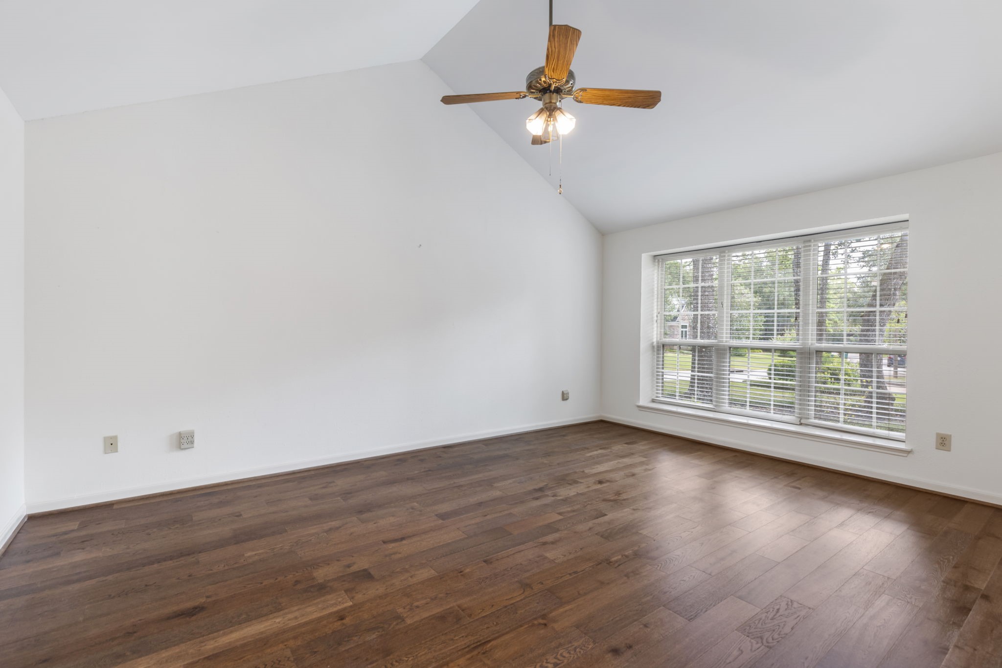 59 Fire Flicker Place Spring, TX 77381 - Photo 18 of 37 Experience serene luxury in this first-floor primary bedroom featuring a vaulted ceiling, abundant natural light from large windows, and elegant floors.
