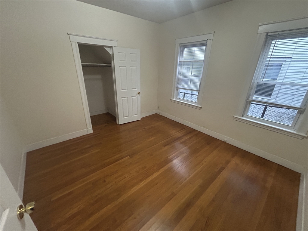 415 Washington Street, Unit 1 Winchester, MA 01890 - Photo 13 of 18 a view of an empty room with wooden floor and a window