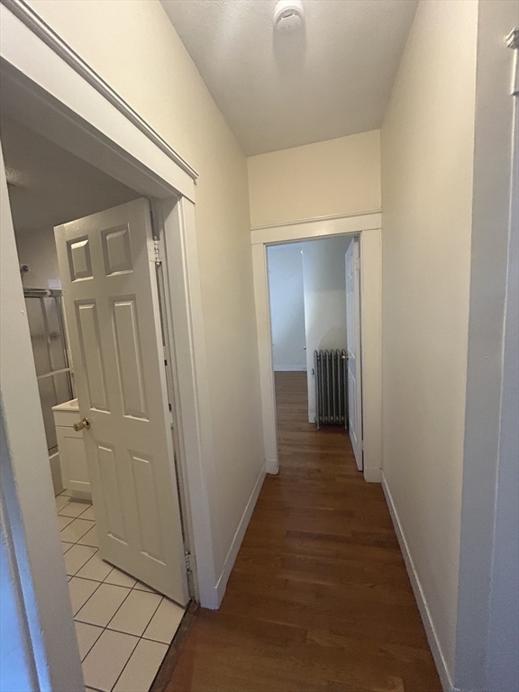 415 Washington Street, Unit 1 Winchester, MA 01890 - Photo 15 of 18 a view of a hallway with wooden floor and a bathroom