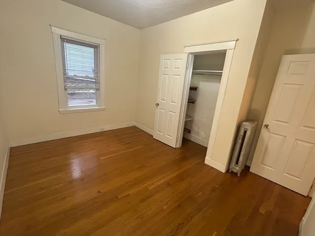 an empty room with wooden floor and a window