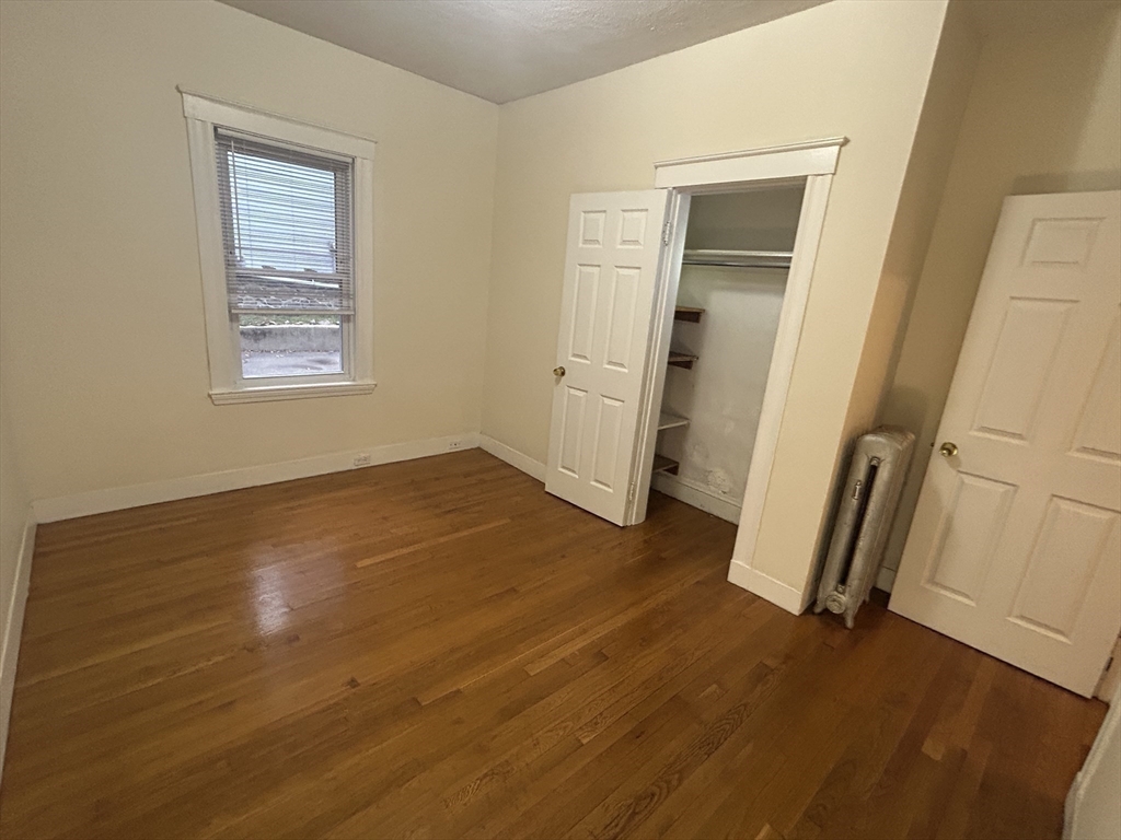 415 Washington Street, Unit 1 Winchester, MA 01890 - Photo 18 of 18 an empty room with wooden floor and a window