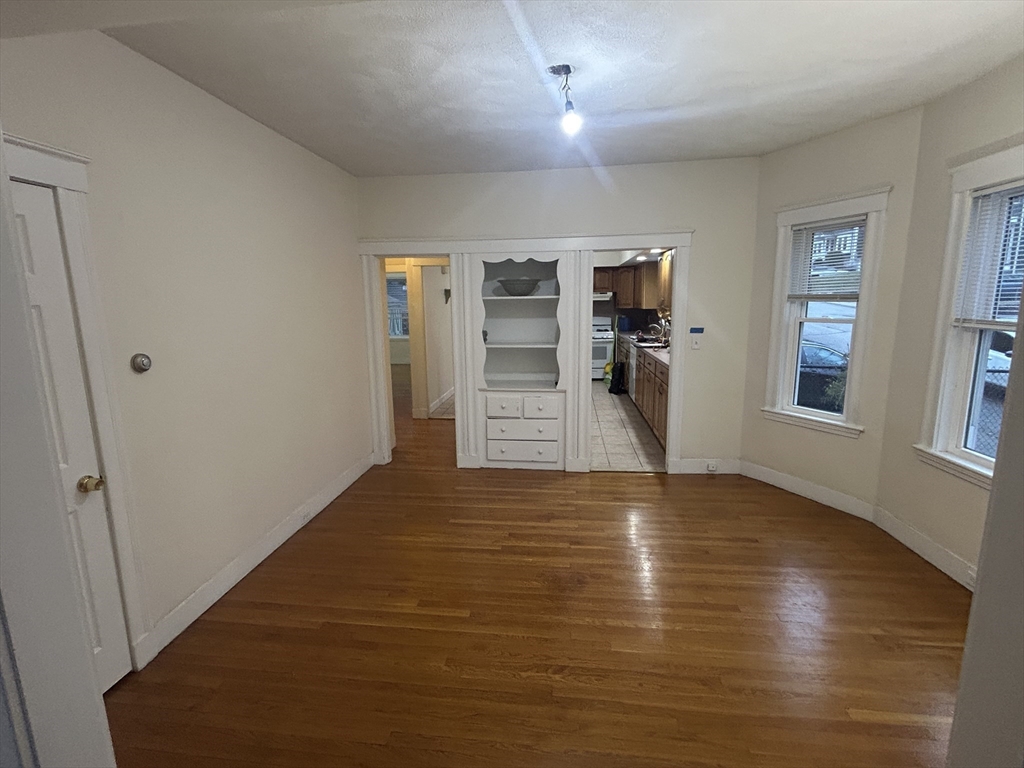 415 Washington Street, Unit 1 Winchester, MA 01890 - Photo 9 of 18 a view of empty room with wooden floor and window