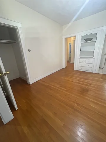 a view of an empty room with closet and workspace