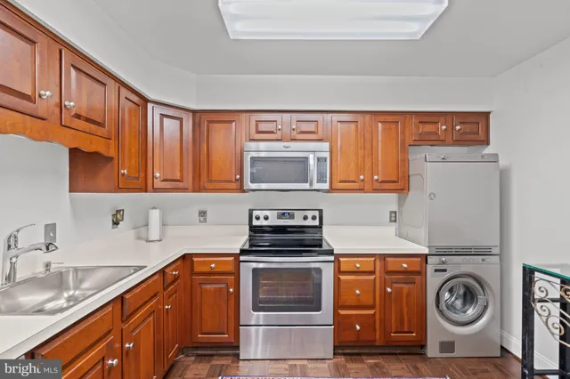 a kitchen with kitchen island a sink a stove and cabinets