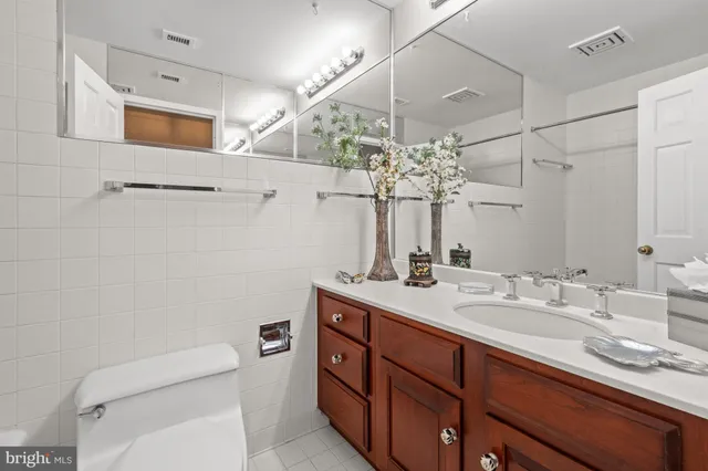a bathroom with a sink a toilet and mirror