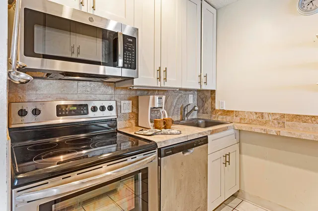 a kitchen with stainless steel appliances a stove a sink and a microwave