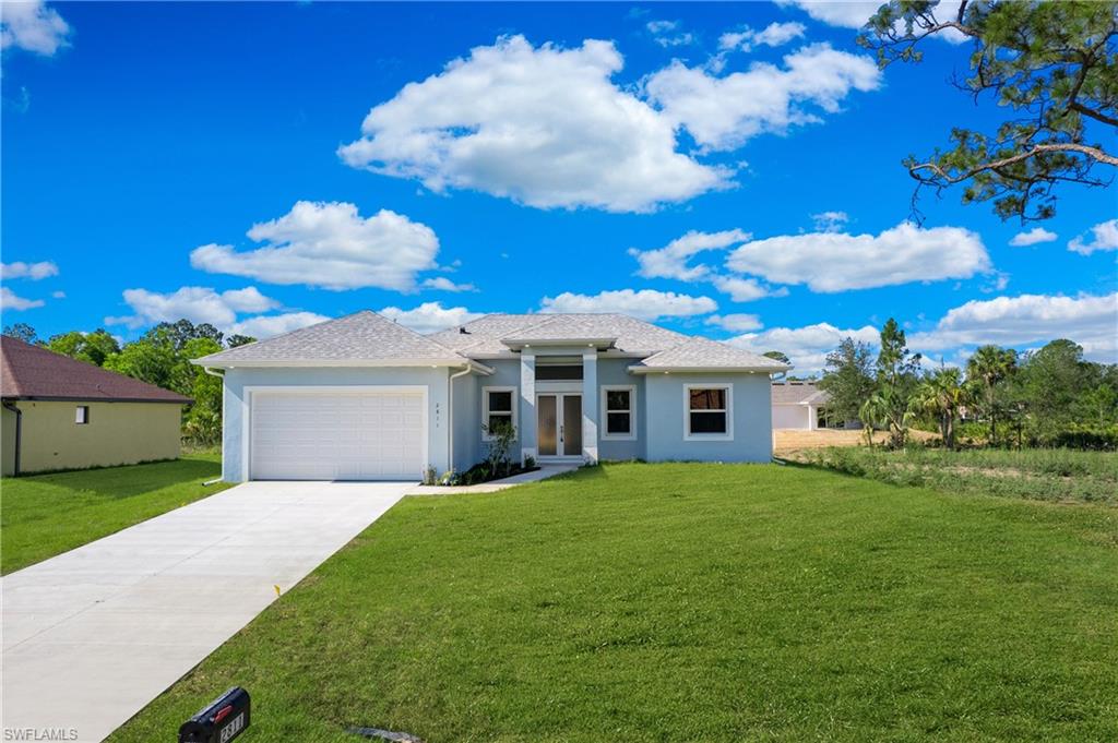 2811 14th Street West Lehigh Acres, FL 33971 - Photo 1 of 33 a white house with a big yard and large trees