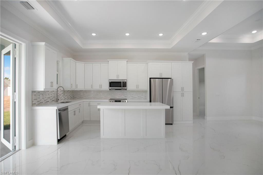 2811 14th Street West Lehigh Acres, FL 33971 - Photo 12 of 33 a kitchen with kitchen island a sink appliances and cabinets