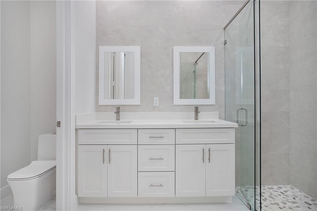 2811 14th Street West Lehigh Acres, FL 33971 - Photo 17 of 33 a bathroom with double sink and a mirror