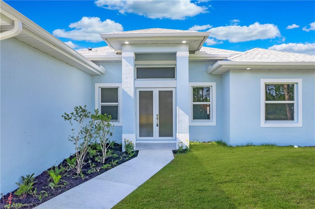 2811 14th Street West Lehigh Acres, FL 33971 - Photo 2 of 33 a front view of a house with a garden