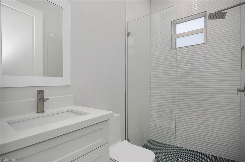 2811 14th Street West Lehigh Acres, FL 33971 - Photo 23 of 33 a bathroom with a toilet a sink and mirror