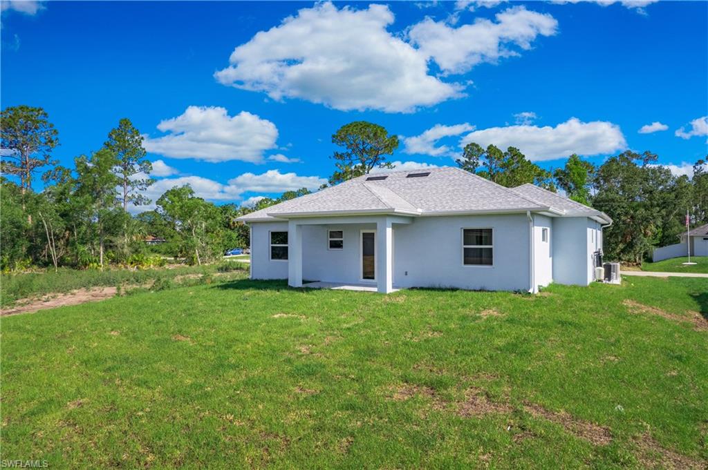 2811 14th Street West Lehigh Acres, FL 33971 - Photo 29 of 33 a white house with a big yard and large trees