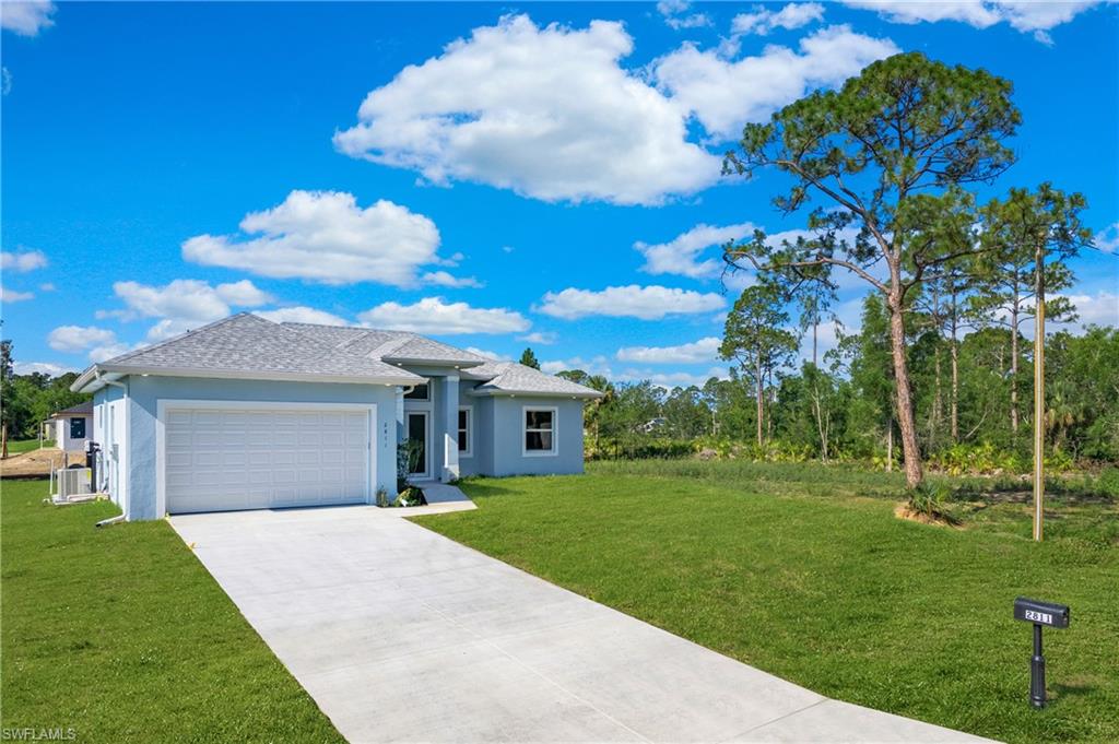 2811 14th Street West Lehigh Acres, FL 33971 - Photo 3 of 33 a front view of a house with a yard