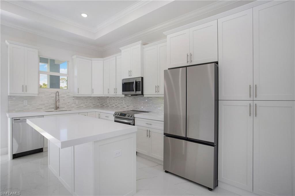 2811 14th Street West Lehigh Acres, FL 33971 - Photo 7 of 33 a kitchen with stainless steel appliances a refrigerator stove microwave and sink