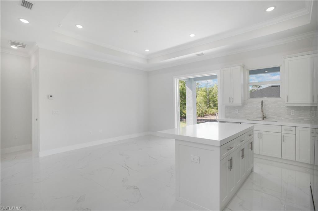 2811 14th Street West Lehigh Acres, FL 33971 - Photo 8 of 33 a large white kitchen with a sink large window and cabinets