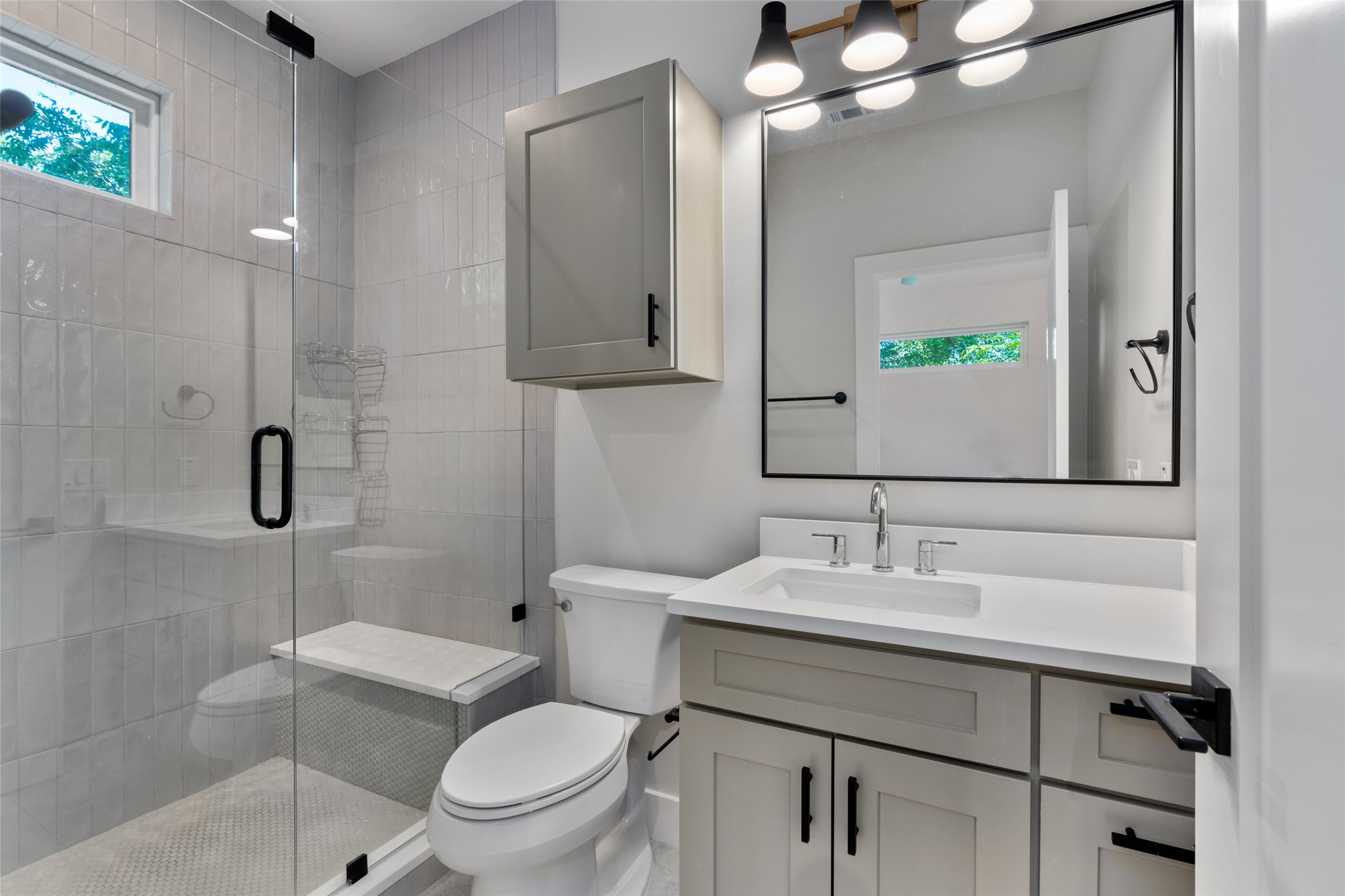 5200 Grover Avenue Austin, TX 78756 - Photo 18 of 32 Contemporary primary bathroom featuring a frameless glass shower enclosure with a built-in bench, a window, and vertical subway tile