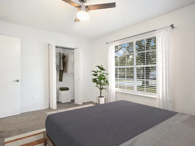 a bedroom with a bed and a large window