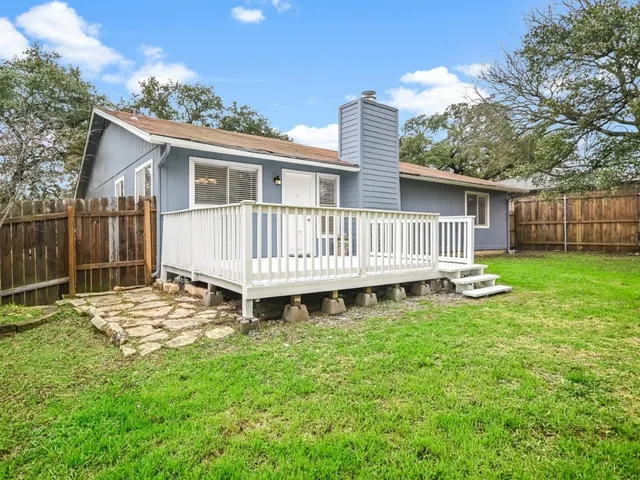 a view of a house with a yard and deck