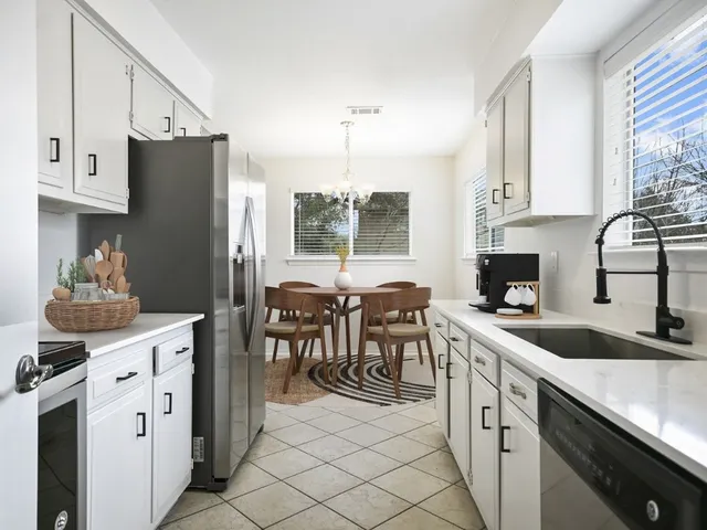 a kitchen with granite countertop a sink stove and refrigerator