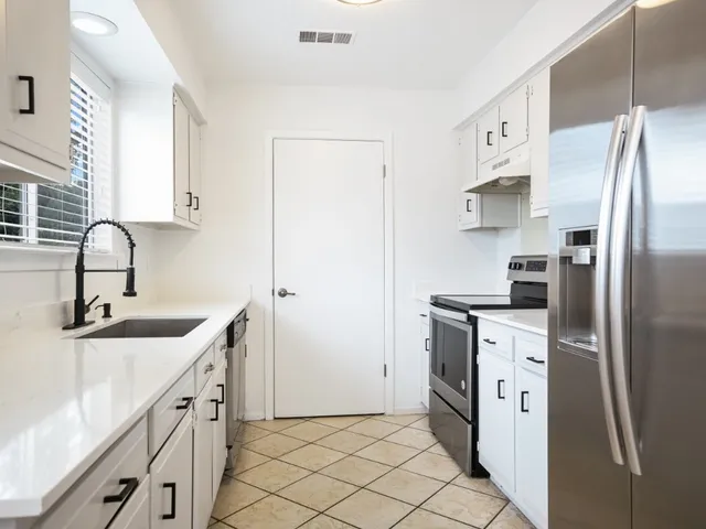 a kitchen with white cabinets and stainless steel appliances