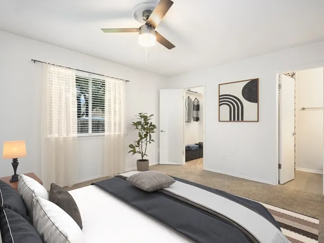 a bedroom with a bed and a large window