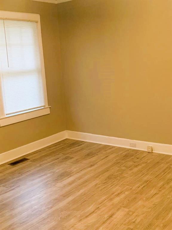 689 Grenada Terrace Macon, GA 31206 - Photo 6 of 9 a view of an empty room with wooden floor and a window