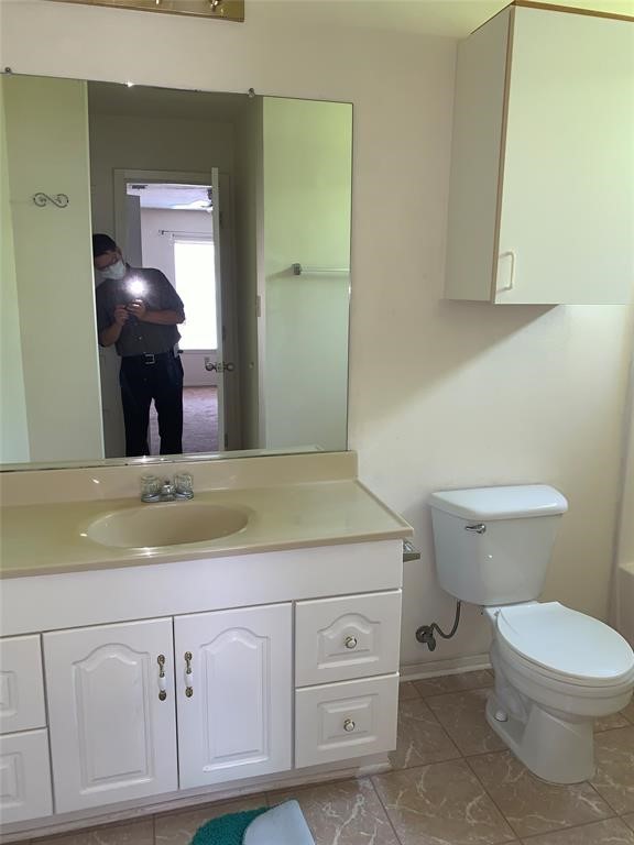 3801 College Main Street, Unit AD Bryan, TX 77801 - Photo 14 of 18 a bathroom with a granite countertop toilet sink and mirror