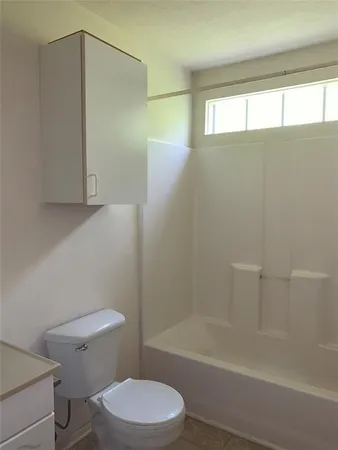 a white toilet sitting next to a bath tub