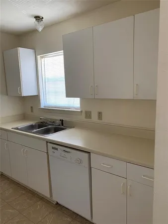 a kitchen with a sink cabinets and window