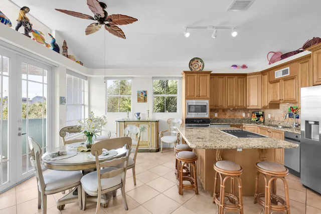 a dining hall with stainless steel appliances granite countertop a stove a sink dishwasher a dining table and chairs with wooden floor