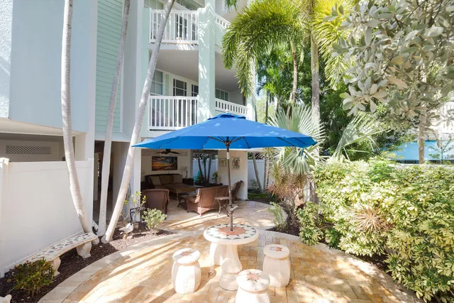 a view of a patio with table and chairs under an umbrella