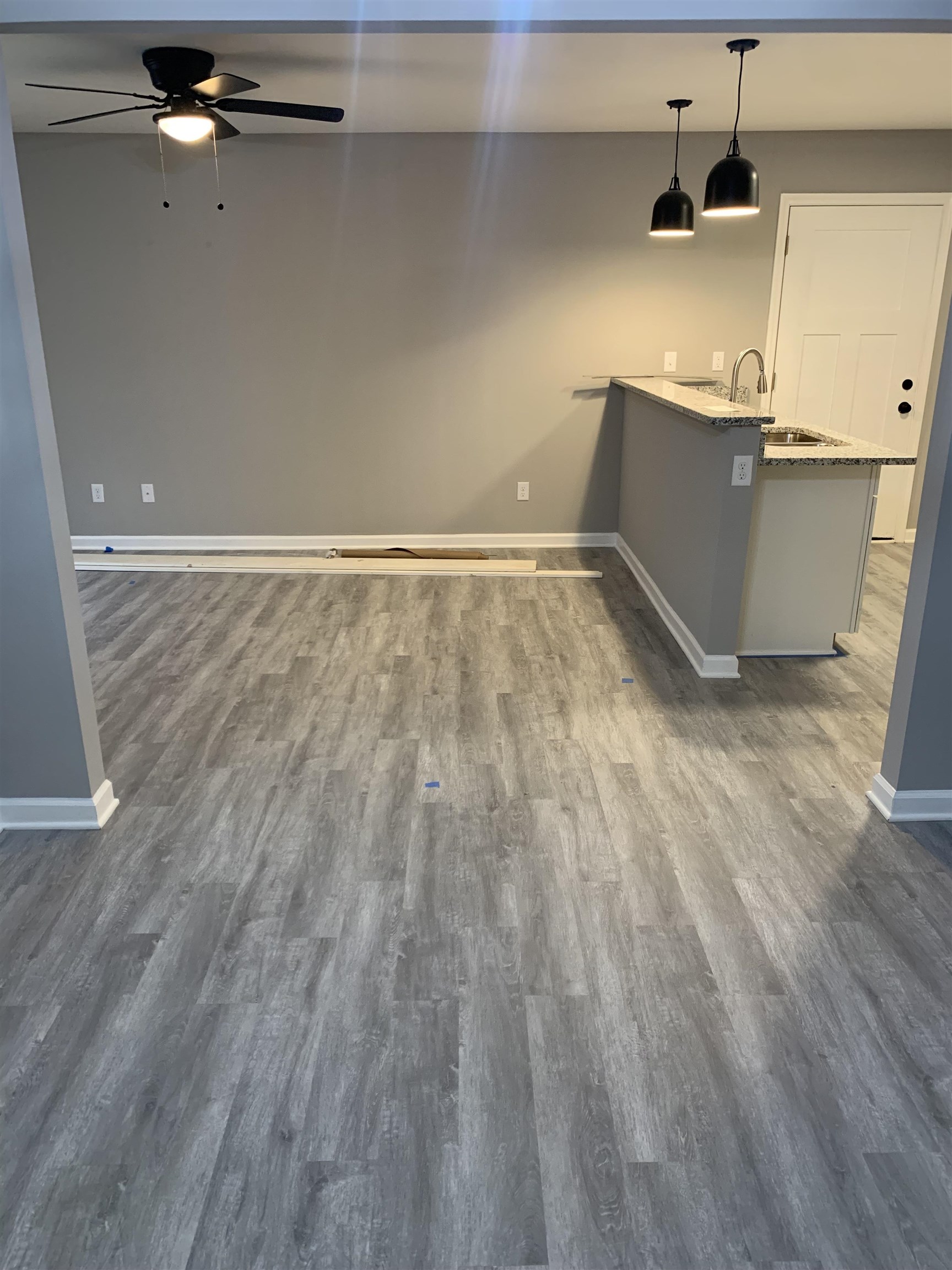 4372 Ryan Street Memphis, TN 38127 - Photo 2 of 9 Bar area with light stone counters, decorative light fixtures, dark wood-style floors, ceiling fan, and gray cabinetry