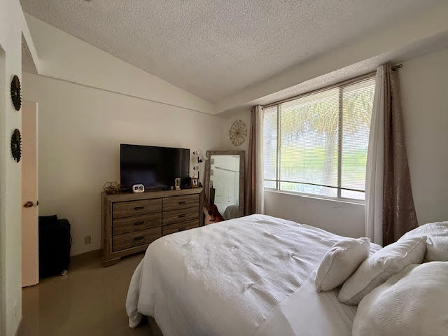 741 Lyons Road, Unit 17201 Coconut Creek, FL 33063 - Photo 17 of 45 a bedroom with a bed and a television