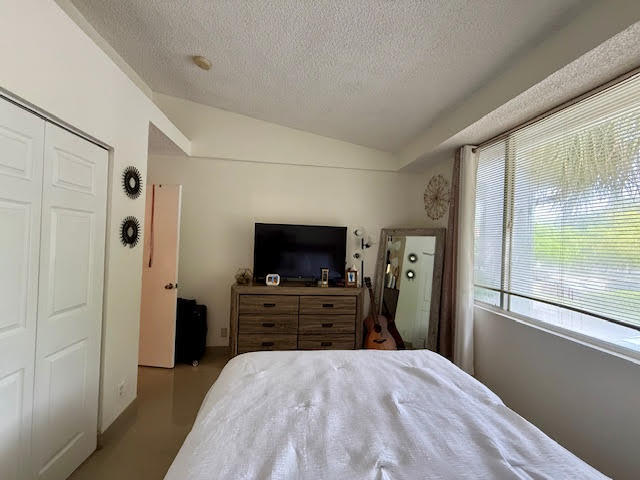741 Lyons Road, Unit 17201 Coconut Creek, FL 33063 - Photo 18 of 45 a view of a bedroom with a flat tv and a bed