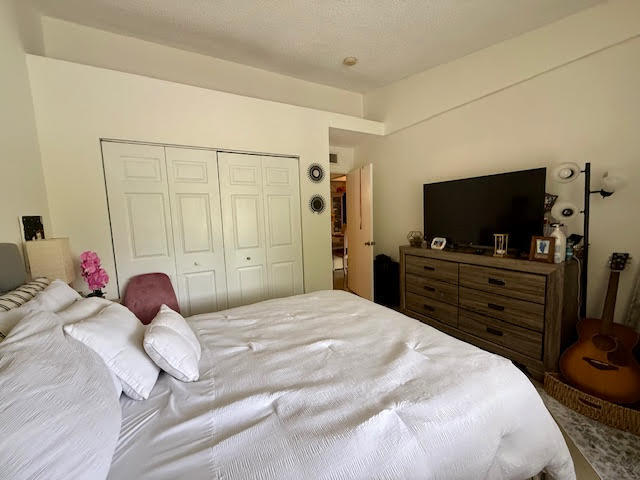 741 Lyons Road, Unit 17201 Coconut Creek, FL 33063 - Photo 19 of 45 a bedroom with a bed and a flat screen tv