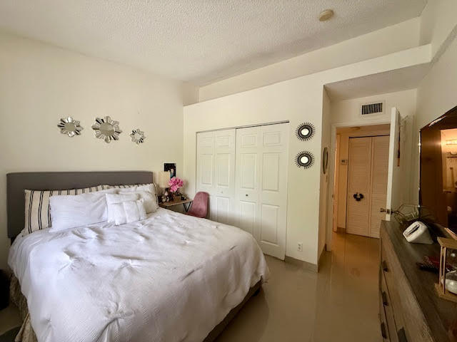 741 Lyons Road, Unit 17201 Coconut Creek, FL 33063 - Photo 21 of 45 a bedroom with a bed and a chandelier