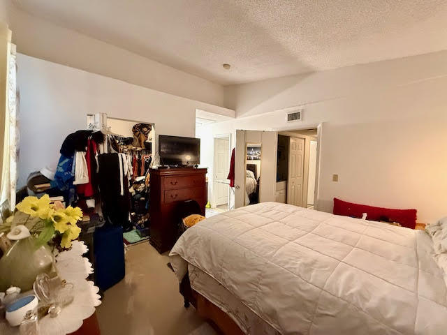 741 Lyons Road, Unit 17201 Coconut Creek, FL 33063 - Photo 28 of 45 a bedroom with a bed and a large mirror