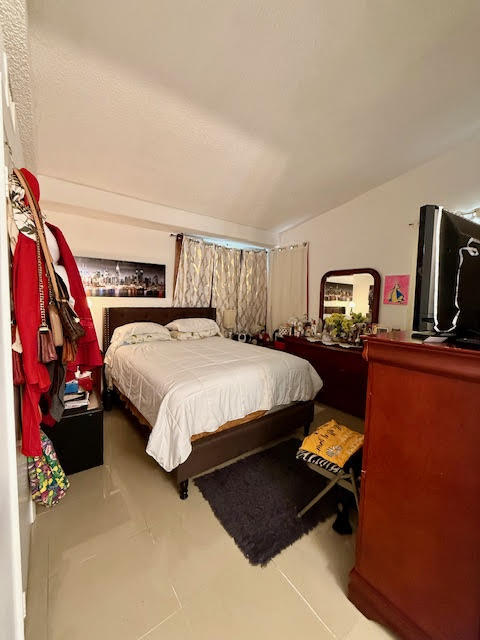 741 Lyons Road, Unit 17201 Coconut Creek, FL 33063 - Photo 29 of 45 a bedroom with bed and tv