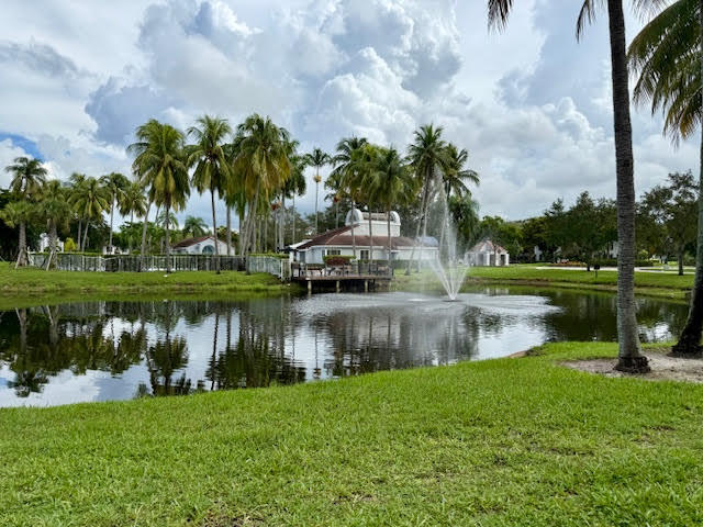741 Lyons Road, Unit 17201 Coconut Creek, FL 33063 - Photo 40 of 45 a view of a lake with houses in the back