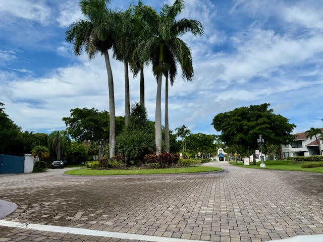 741 Lyons Road, Unit 17201 Coconut Creek, FL 33063 - Photo 44 of 45 a palm tree sitting in front of a house with a yard