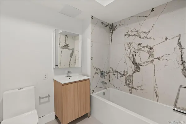 a bathroom with a sink mirror toilet and bathtub