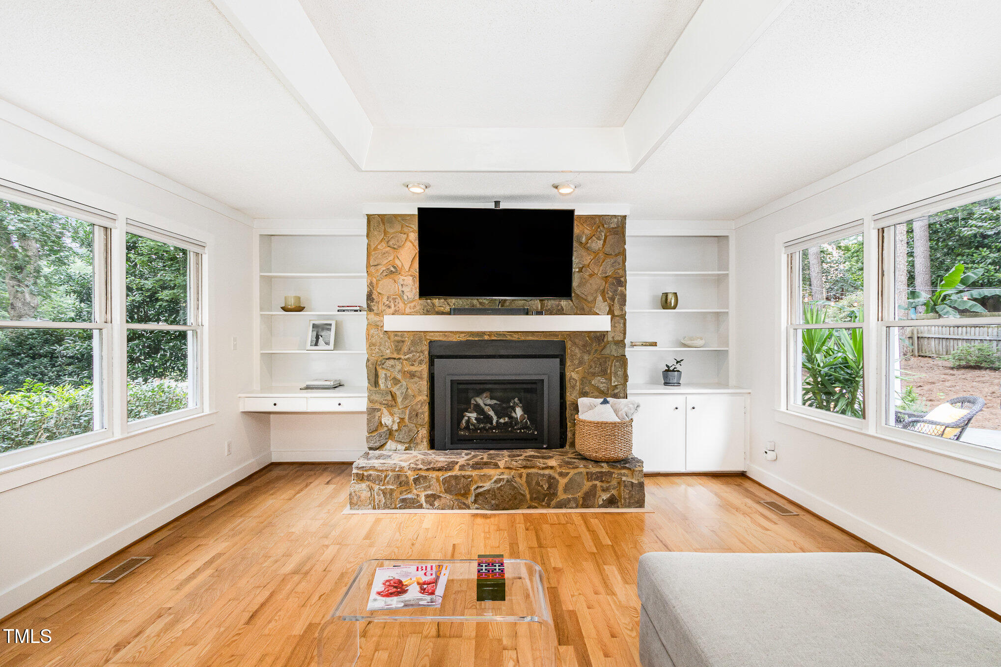 6025 Tarnhour Court Raleigh, NC 27612 - Photo 12 of 27 a living room with furniture a flat screen tv and a fireplace