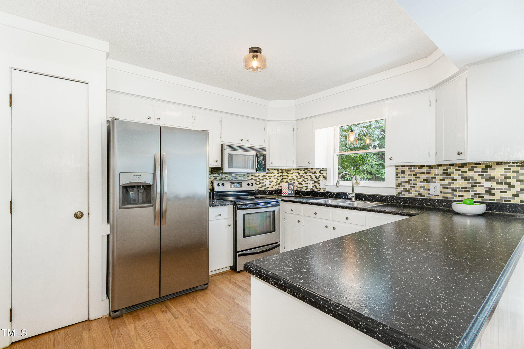 6025 Tarnhour Court Raleigh, NC 27612 - Photo 15 of 27 a kitchen with stainless steel appliances granite countertop a refrigerator a stove and a sink with wooden floor