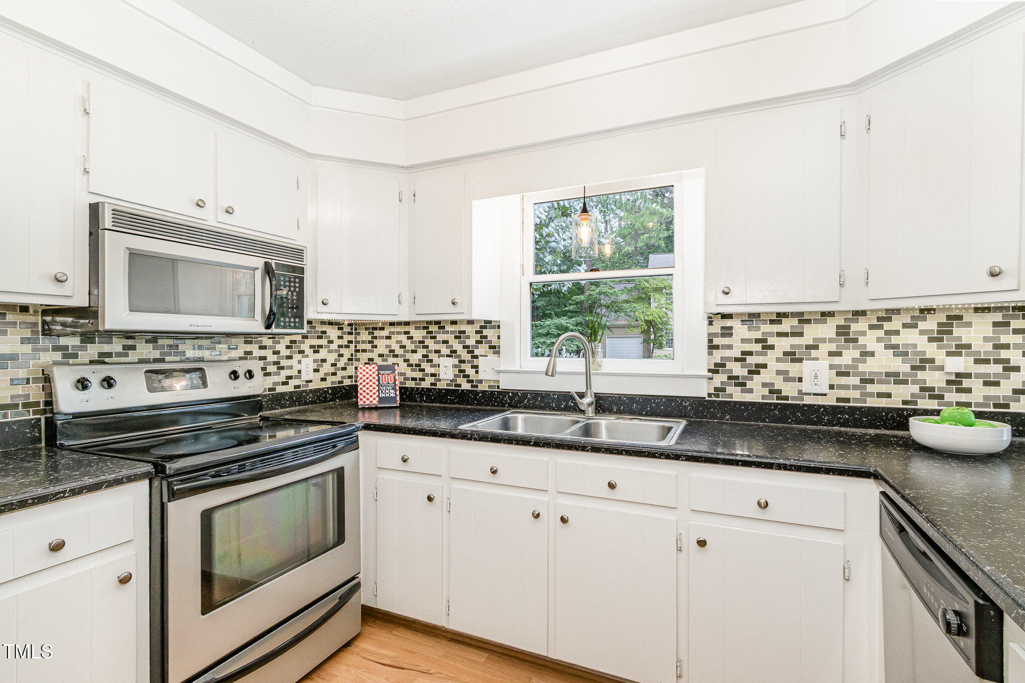 6025 Tarnhour Court Raleigh, NC 27612 - Photo 16 of 27 a kitchen with granite countertop white cabinets and white appliances