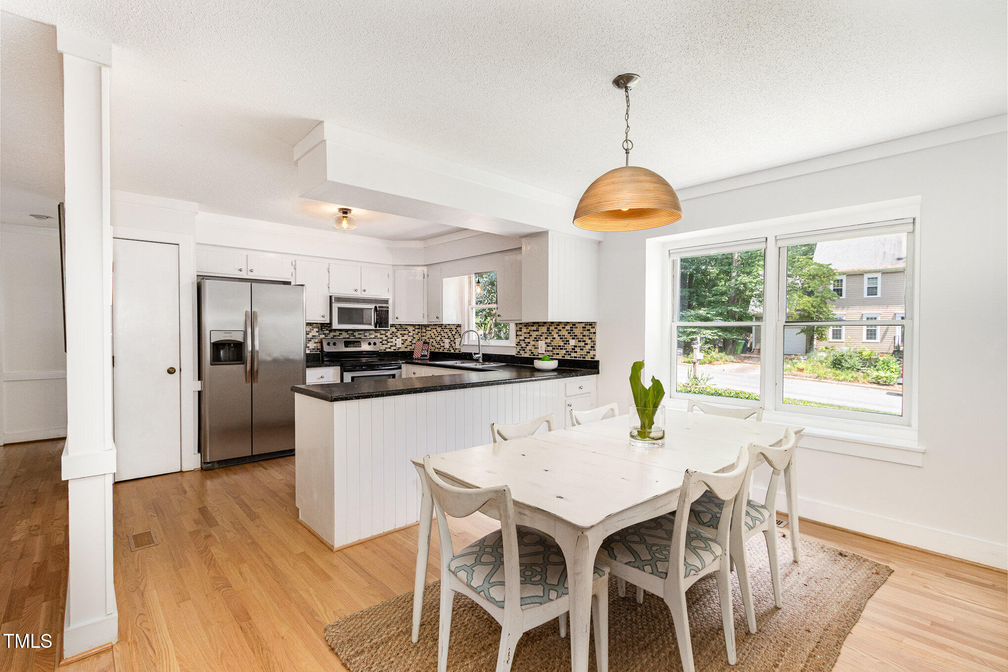 6025 Tarnhour Court Raleigh, NC 27612 - Photo 2 of 27 a kitchen with stainless steel appliances granite countertop a dining table chairs and white cabinets